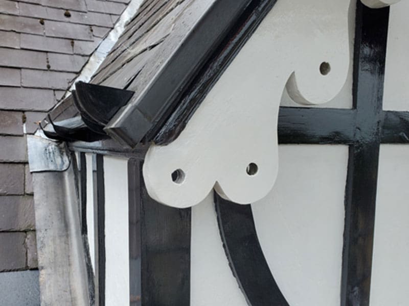 Rot repair on a Tudor fascia board on roof in Bath which had suffered serious rot damage and been repaired with Repair Care filler on a roof in Bath. Finished in Black and white paint and part if larger project.