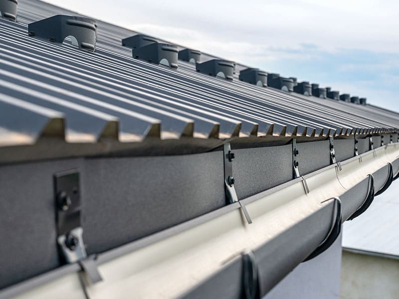New metal guttering installed on a new metal roof to take away rain water. Installed as part of a roof repair.